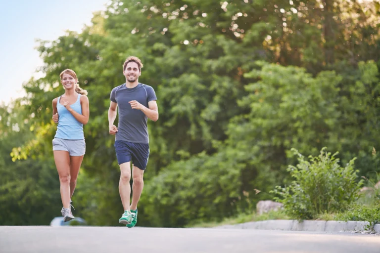 Man and woman running outdoors, demonstrating that regular exercise does not cause hair loss