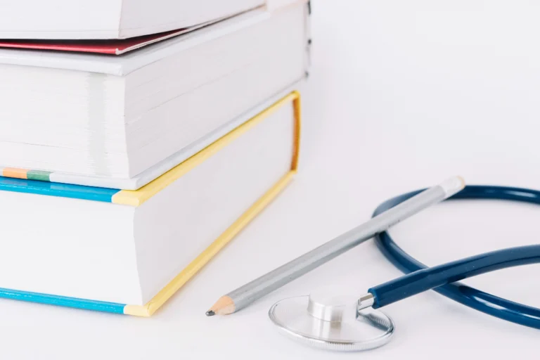 Stack of medical books with a stethoscope symbolising a hair transplant glossary and clear definitions.