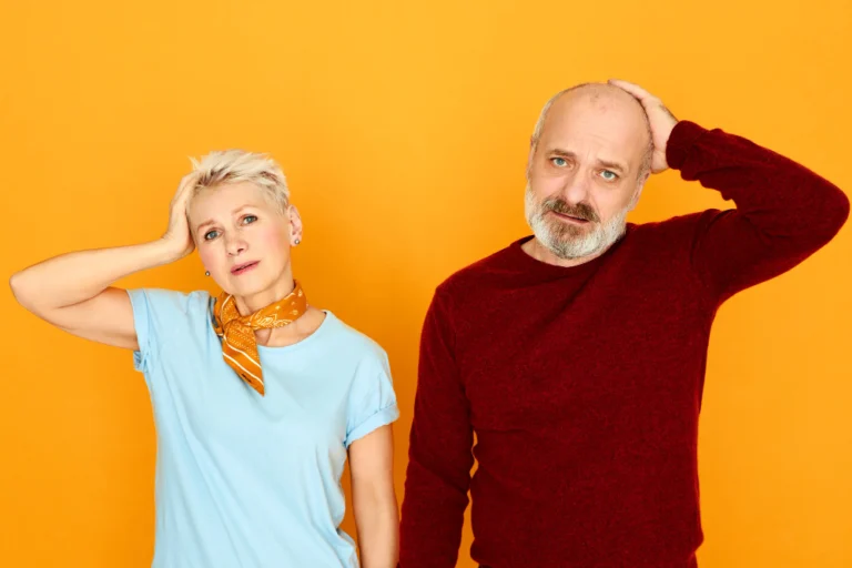 Man and woman checking their hairlines while facing hair loss together