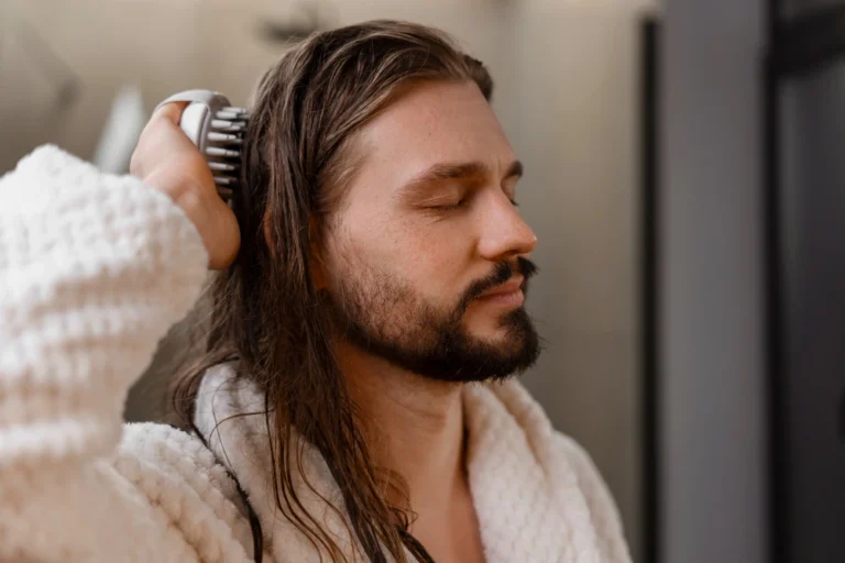 Man massaging his scalp with a silicone scalp massager for scalp massage hair growth