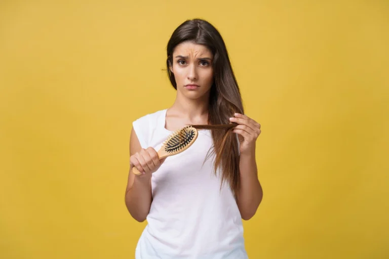 Woman brushing her hair and seeing strands fall due to seasonal hair shedding